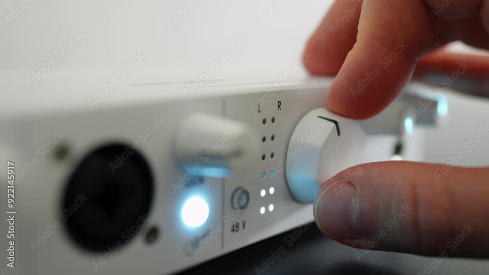 Man turning a volume knob on an audio interface. Close up Man turning a volume knob on an audio interface. Close up