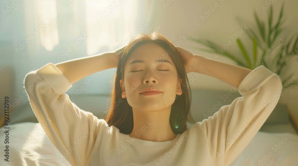 Young woman enjoying a peaceful moment with eyes closed, relaxing at home, sunlight streaming through the window. Young woman enjoying a peaceful moment with eyes closed, relaxing at home, sunlight streaming through the window.