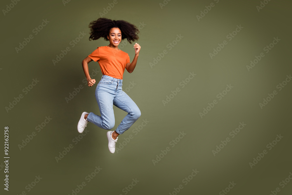 © deagreez - Full length photo of charming positive woman wear orange t-shirt jumping high running empty space isolated khaki color background © deagreez - Full length photo of charming positive woman wear orange t-shirt jumping high running empty space isolated khaki color background