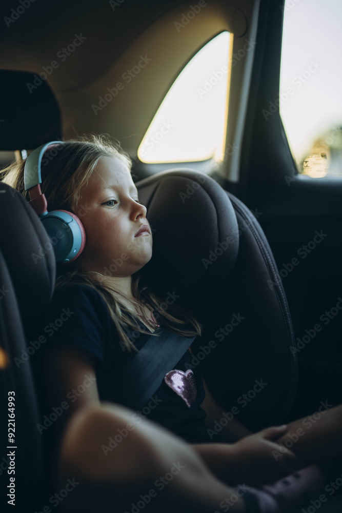 Cute little girl sitting in child safety seat inside car Cute little girl sitting in child safety seat inside car