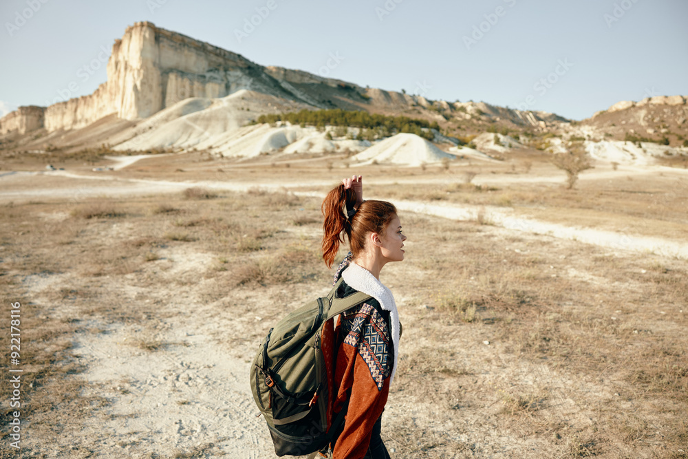 Naklejka premium Exploring the vast desert woman with backpack gazing at majestic mountain range in the distance