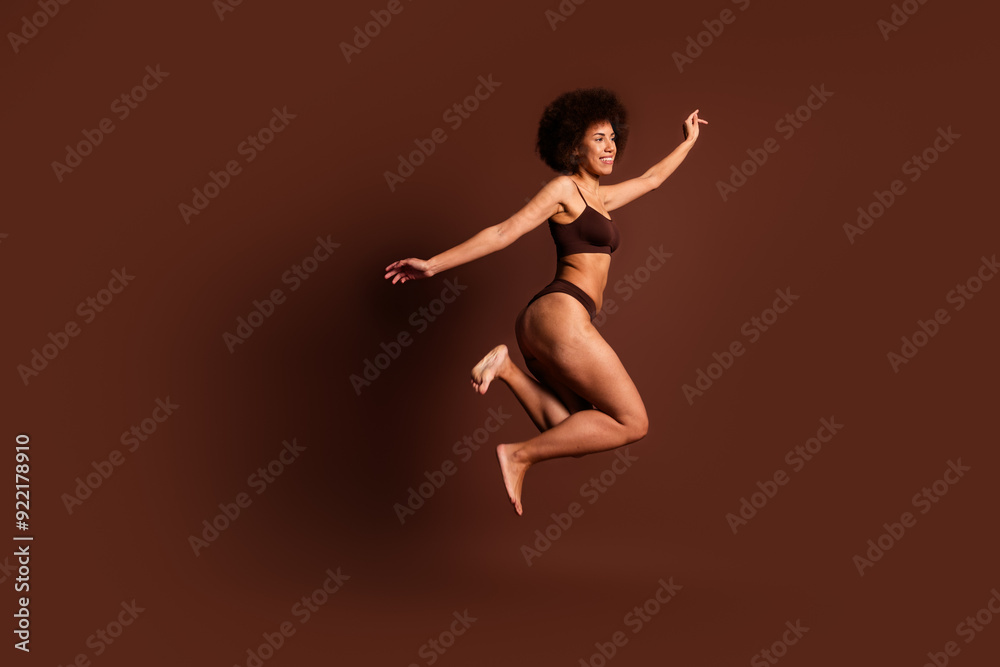 Obraz premium Full length photo of excited funky lady underwear jumping enjoying girls power isolated brown color background