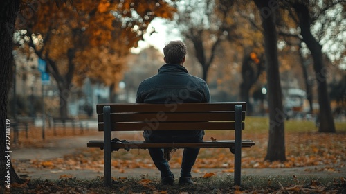 Man Sitting on a Bench in the Autumn Park