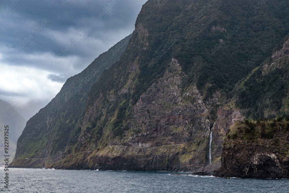 Rocky coast with a waterfall near the town of Seixal on the island of Madeira