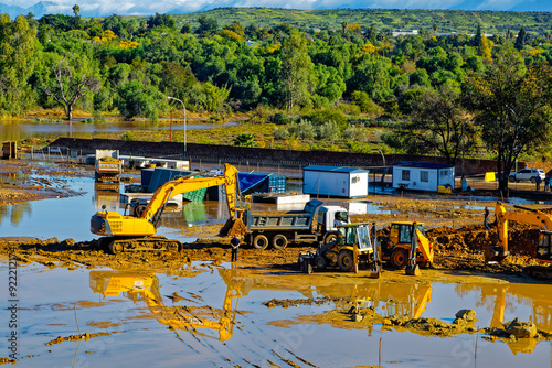 Excavator pushing stuck truck on flooded construction site after heavy rain on the outskirts of Oudtshoorn, Western Cape, South Africa photo