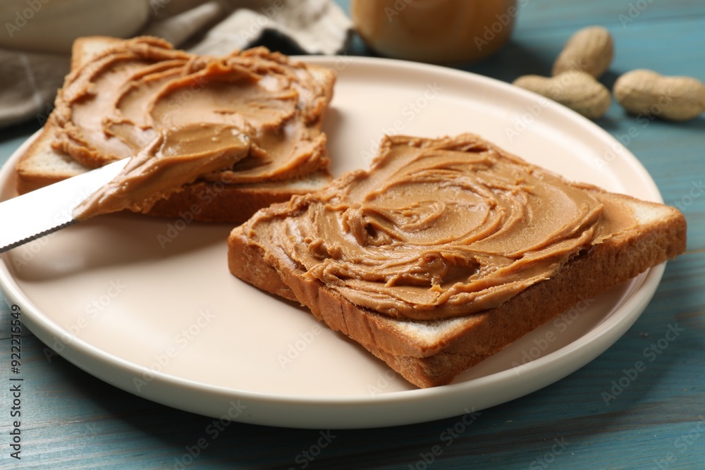 Tasty sandwiches with peanut butter on light blue wooden table, closeup Tasty sandwiches with peanut butter on light blue wooden table, closeup