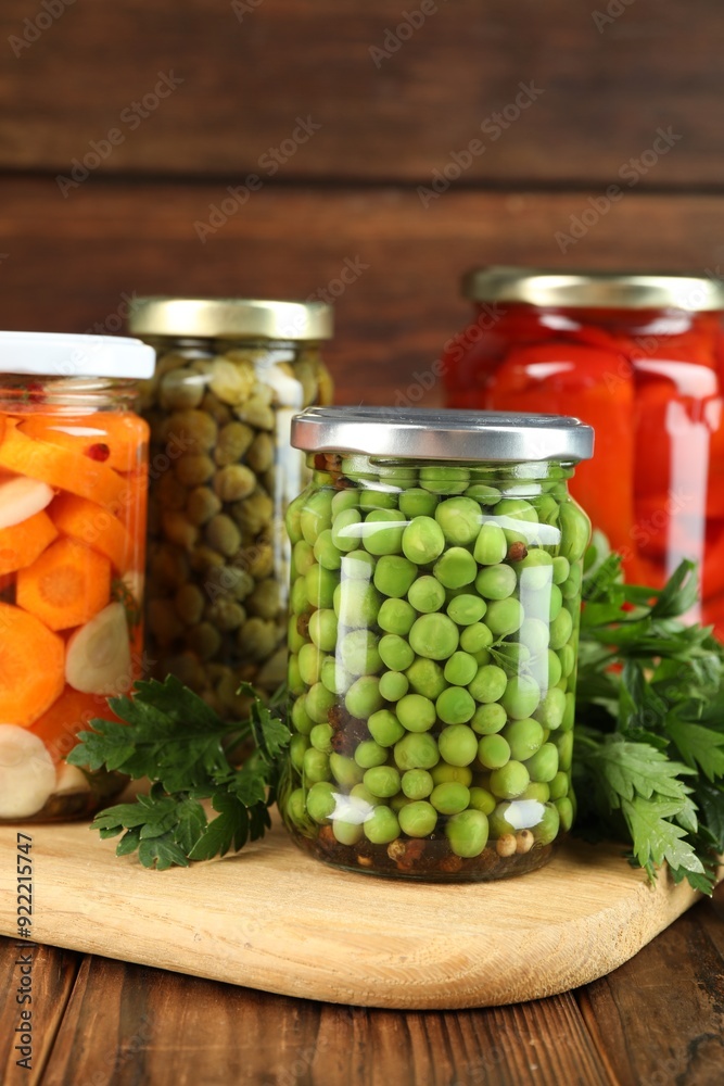 Different pickled products in jars and fresh parsley on wooden table Different pickled products in jars and fresh parsley on wooden table
