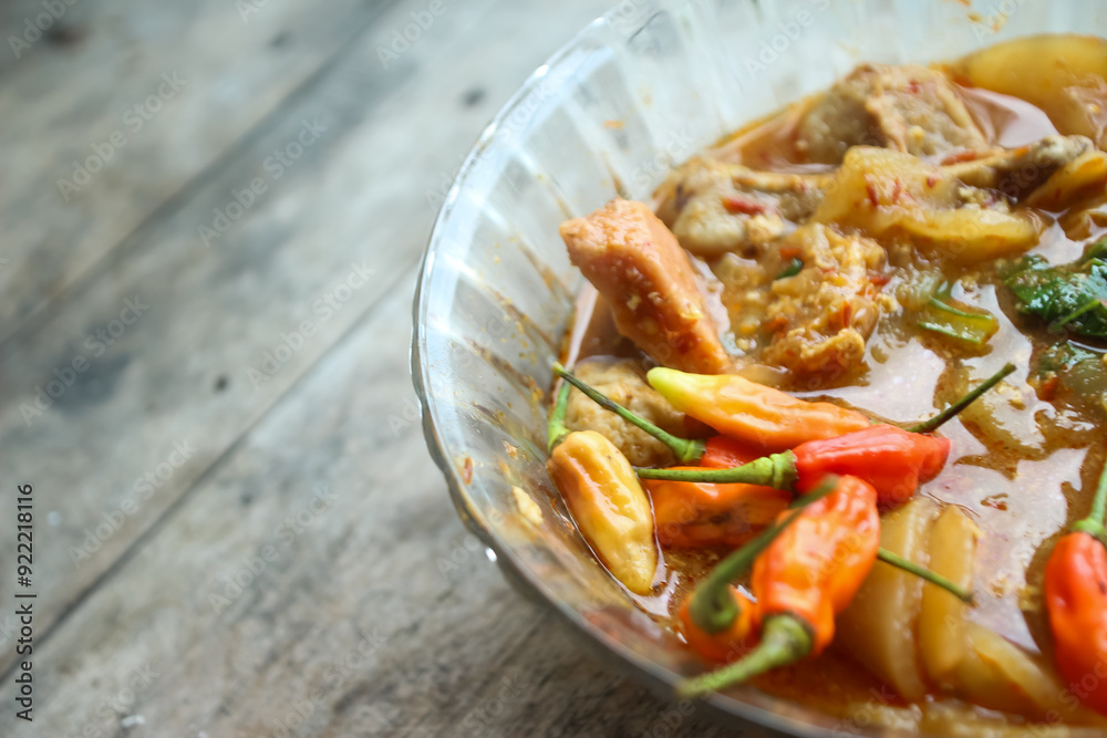 Seblak is a typical Indonesian dish with a savory and spicy taste. Made from wet crackers cooked with vegetables, sausage, eggs. a bowl of seblak on a wooden table. Seblak is a typical Indonesian dish with a savory and spicy taste. Made from wet crackers cooked with vegetables, sausage, eggs. a bowl of seblak on a wooden table.