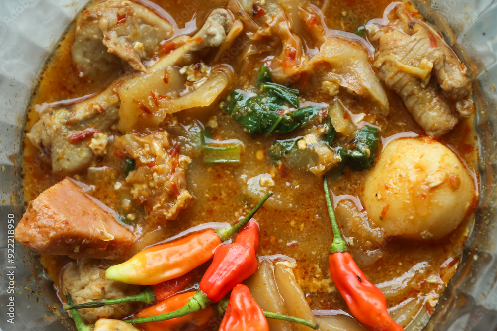 Seblak is a typical Indonesian dish with a savory and spicy taste. Made from wet crackers cooked with vegetables, sausage, eggs. a bowl of seblak on a wooden table. Seblak is a typical Indonesian dish with a savory and spicy taste. Made from wet crackers cooked with vegetables, sausage, eggs. a bowl of seblak on a wooden table.
