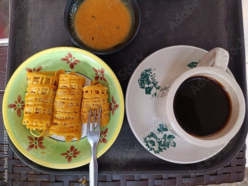 roti jala or lace pancakes or Malaysian net crepes with black coffee and peanut sauce