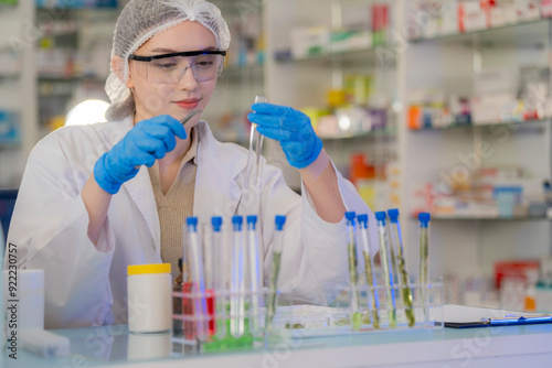 Scientists prepare for the experiment by wearing latex gloves. An experimenter arranges experimental equipment on a table with test tubes and chemicals for making drugs and biochemical for human. photo