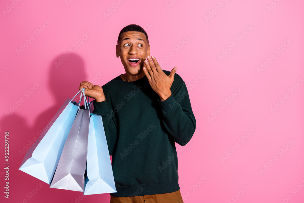 Photo of handsome impressed guy wear sweatshirt holding shoppers looking emtpy space isolated pink color background Photo of handsome impressed guy wear sweatshirt holding shoppers looking emtpy space isolated pink color background