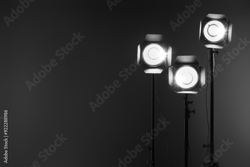 Dark photo background and professional lighting equipment in studio. Space for text