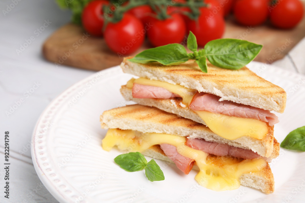 Pieces of toasted bread with melted cheese, ham and basil on table, closeup Pieces of toasted bread with melted cheese, ham and basil on table, closeup