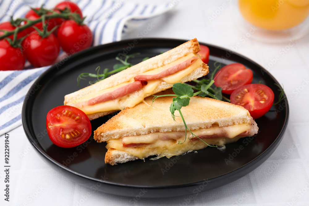 Pieces of toasted bread with melted cheese, ham and tomatoes on white tiled table Pieces of toasted bread with melted cheese, ham and tomatoes on white tiled table