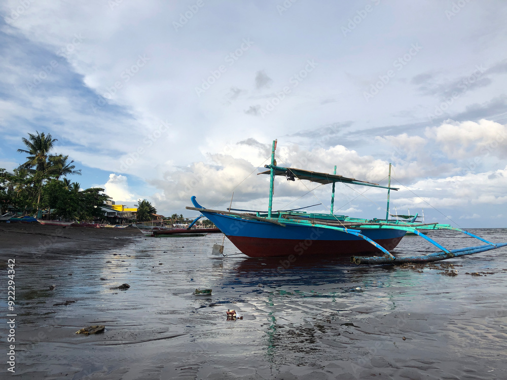 Beautiful view of a boat anchored by the sea on a bright, sunny, and cloudy day. Beautiful view of a boat anchored by the sea on a bright, sunny, and cloudy day.