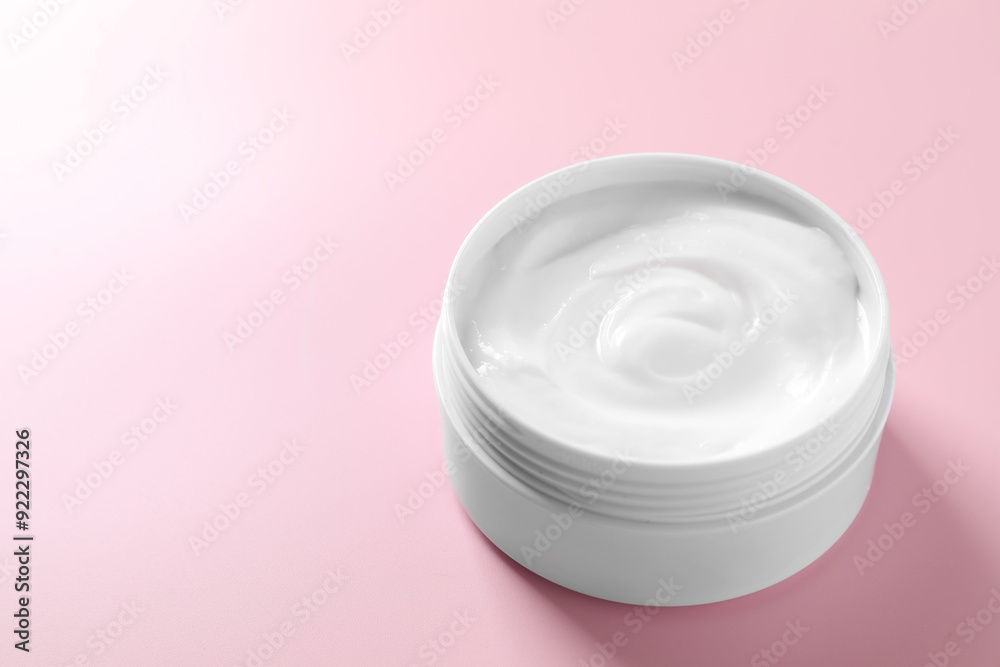 Face cream in jar on pink background, closeup. Space for text Face cream in jar on pink background, closeup. Space for text