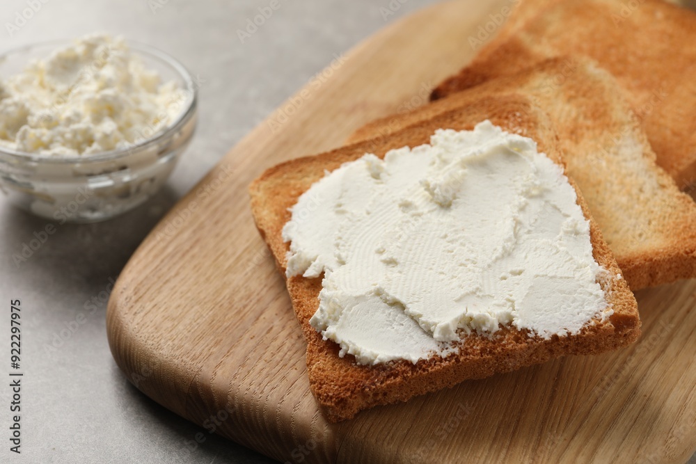 Delicious toasted bread slices with cream cheese on grey table, closeup Delicious toasted bread slices with cream cheese on grey table, closeup