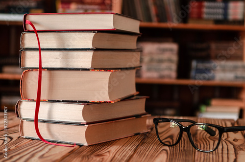 Old books stand against the background of bookshelves. Library.