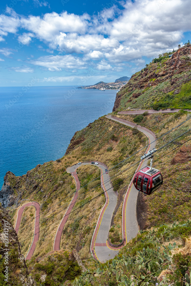 Cristo Rei. Jesus monument on top of a cliff overlooking the Atlantic Ocean and a cable car leading down to the beach on the island of Madeira