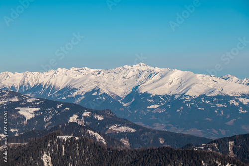 Scenic view of majestic snow capped mountain peak Hochalmspitze in High Tauern seen from Kobesnock, Bad Bleiberg, Carinthia, Austria, Europe. Remote wilderness in winter wonderland in Austrian Alps photo