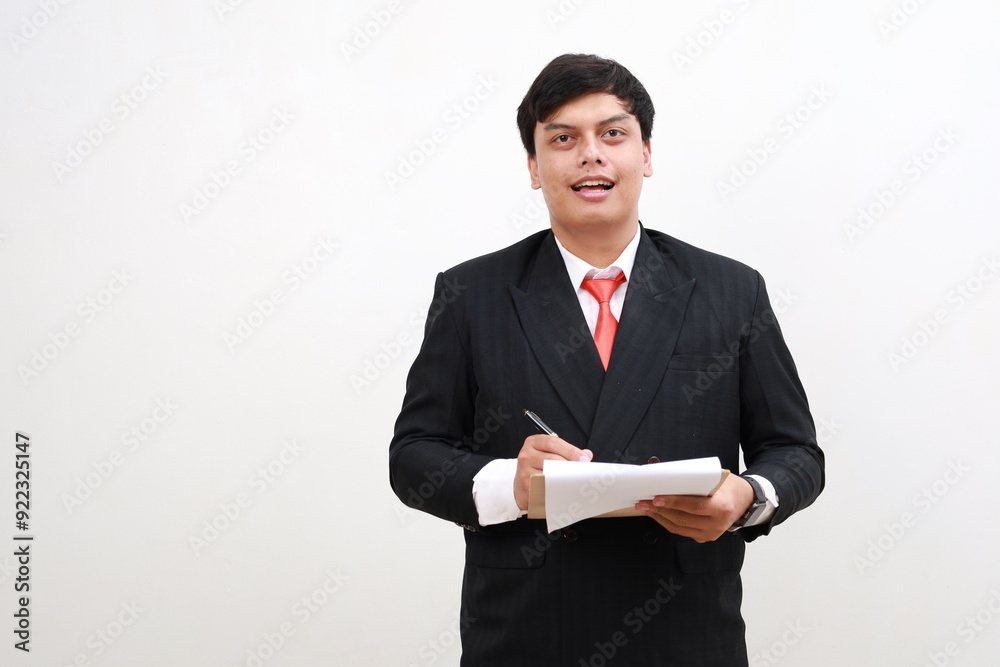 Cheerful young asian businessman posing Holding clipboard with papers document write notes isolated on white background. Mock up copy space. Cheerful young asian businessman posing Holding clipboard with papers document write notes isolated on white background. Mock up copy space.