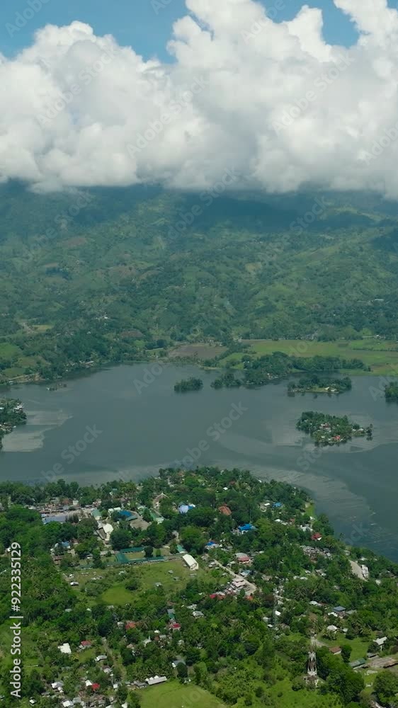 Aerial survey of body of water surrounded by agricultural land. Lake Sebu and rice fields. Mindanao, Philippines. Travel destinations. Vertical view.