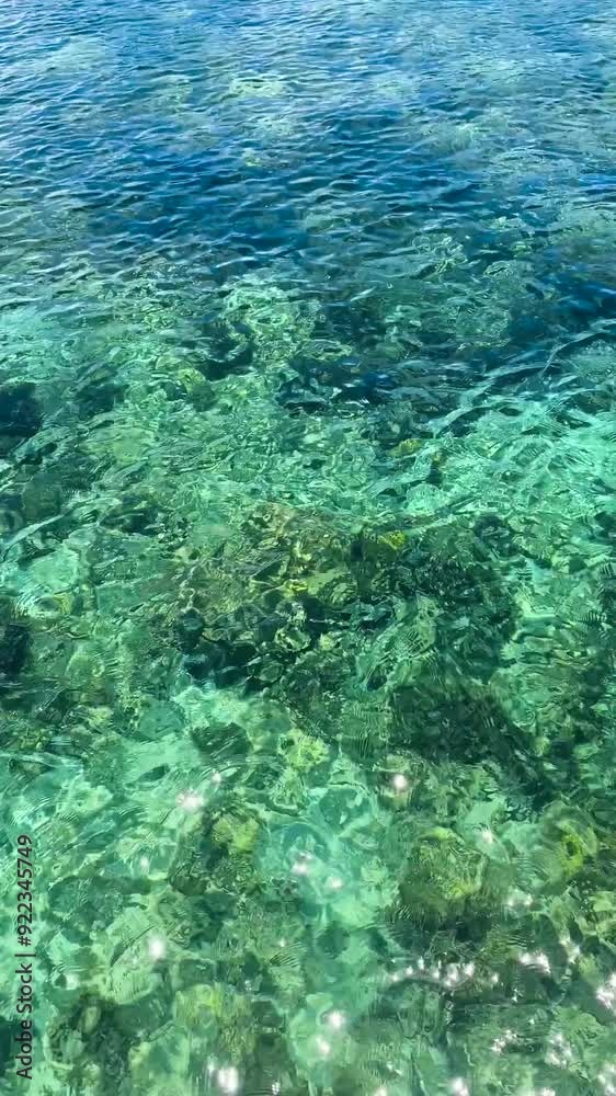 Sunlight over the greenish sea water with corals in the Philippines. Vertical view. Sunlight over the greenish sea water with corals in the Philippines. Vertical view.