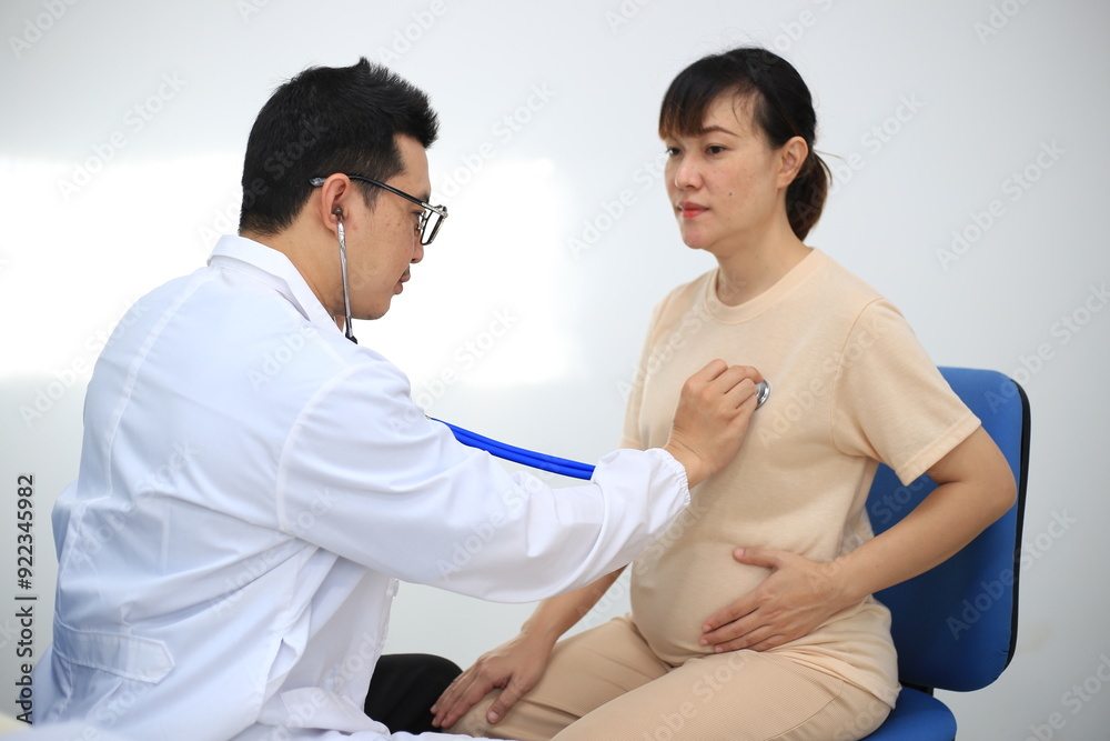 Fototapeta premium Male doctor with experience examining young pregnant women