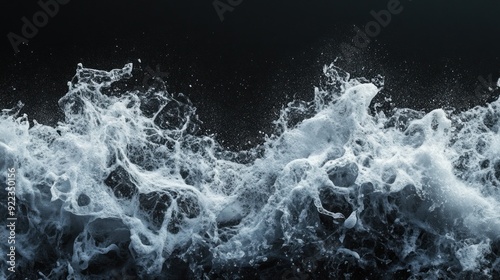 A detailed view of a foamy wave on a dark background.