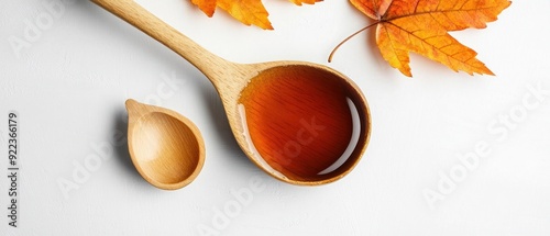 Maple Syrup in Wooden Spoon with Autumn Leaves photo