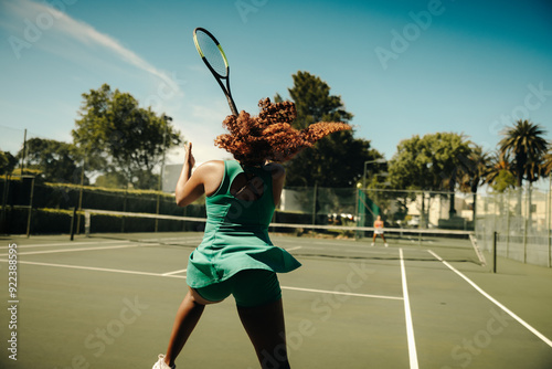 Female tennis player hitting a hard backhand shot during an intense outdoor rally