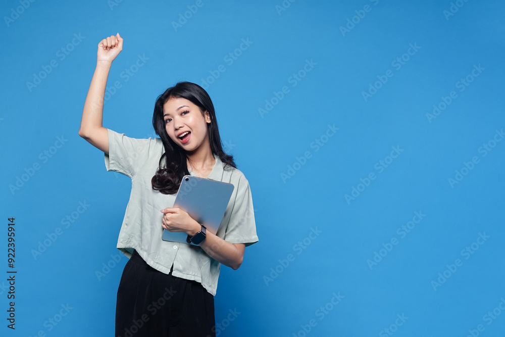 Happy success asian women holding Ipad isolated on blue background Happy success asian women holding Ipad isolated on blue background