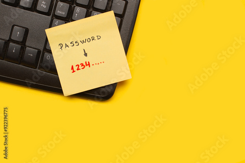 Un post it con la palabra contraseña junto a un teclado de ordenador sobre un fondo amarillo. Vista superior y de cerca. Copy psace photo