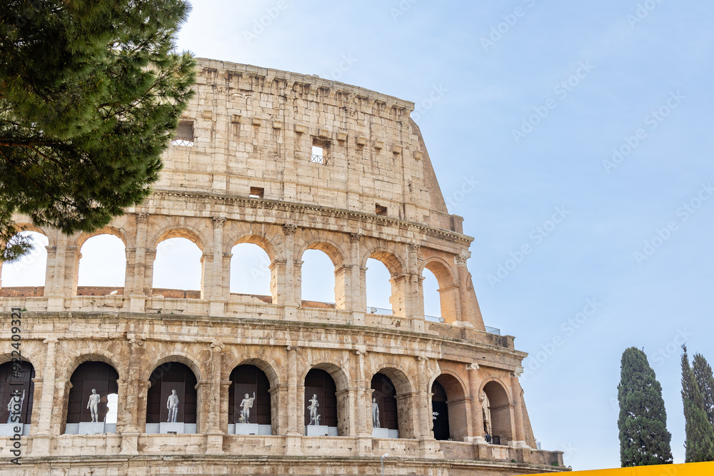 Obraz premium Rome, Italy - April 09, 2024: Ruins of the Coliseum with tourists strolling among the archaeological remains in Rome, Italy