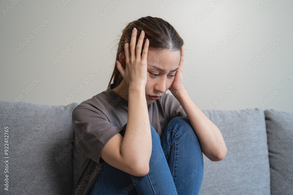 Unhappy anxiety young Asian woman covering her face with pillow on the cough in the living room at home. Unhappy anxiety young Asian woman covering her face with pillow on the cough in the living room at home.