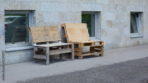 Makeshift benches made of wooden pallets stand near the wall