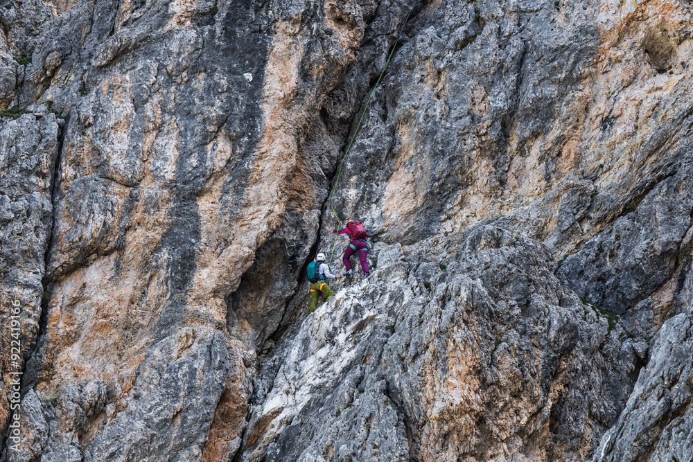 Two rock climbers climb a massive cliff on a sunny day. Extreme sports. Two rock climbers climb a massive cliff on a sunny day. Extreme sports.
