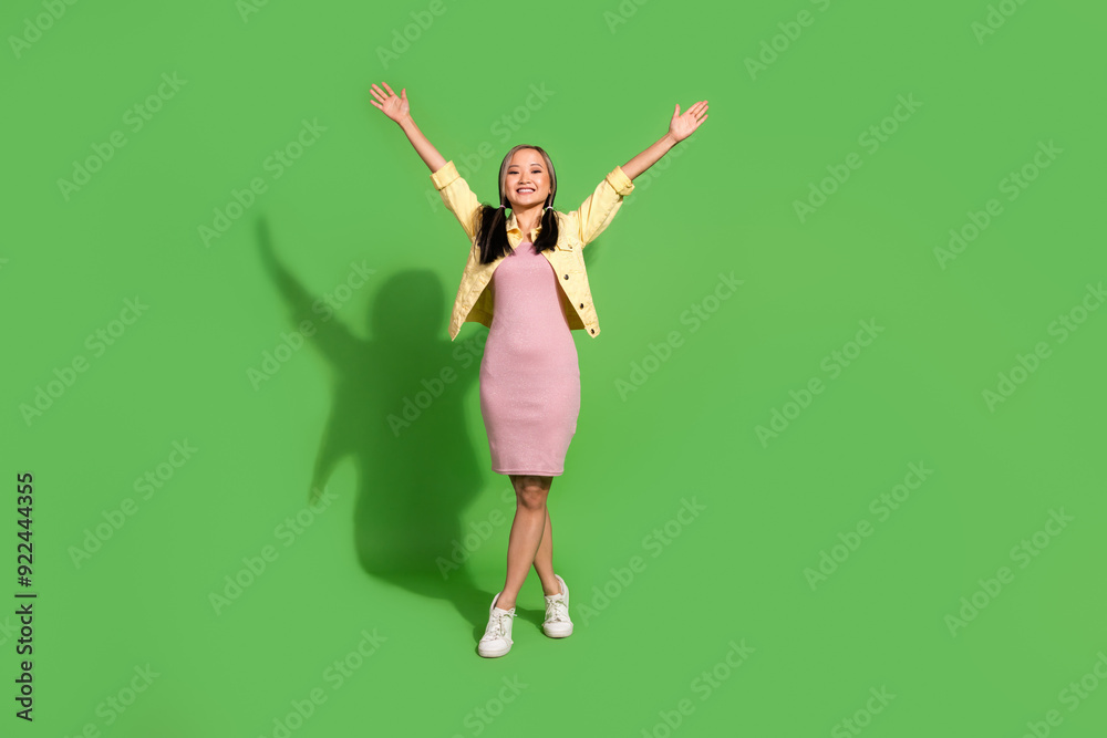 Full size photo of nice young girl raise arms wear jacket dress isolated on green color background Full size photo of nice young girl raise arms wear jacket dress isolated on green color background