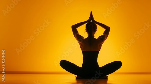 Zen Yoga Silhouette: Peaceful Person in Cobra Pose with Warm Glow on Minimal Yellow Background.