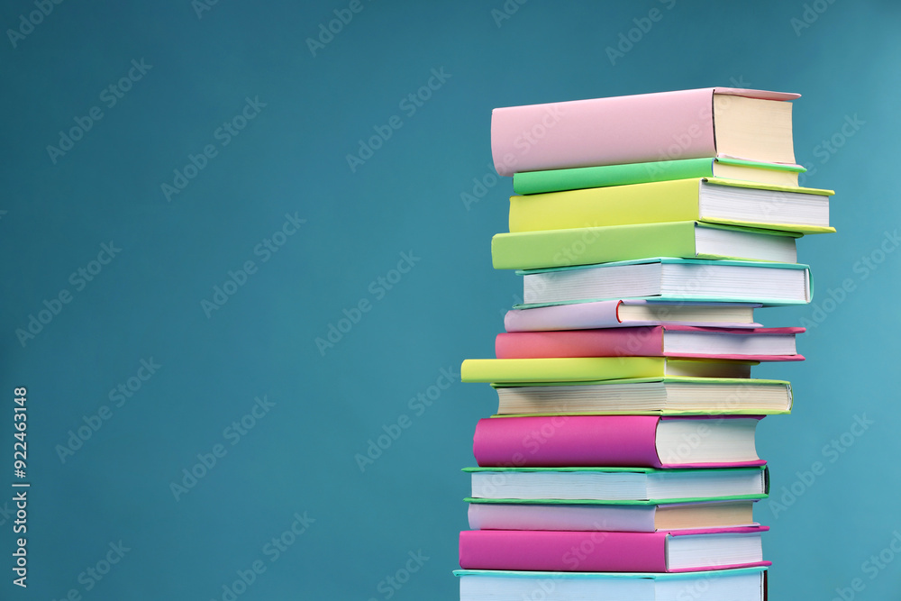 Stack of colorful books on light blue background, space for text Stack of colorful books on light blue background, space for text