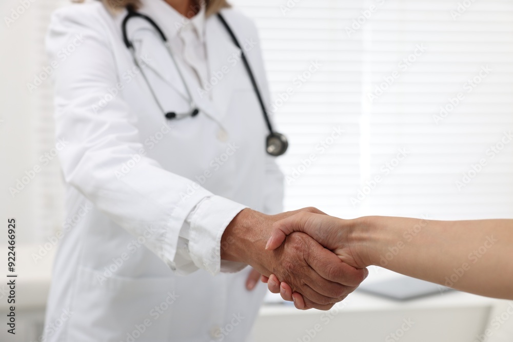 Senior doctor shaking hands with patient in hospital, closeup Senior doctor shaking hands with patient in hospital, closeup