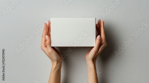 A model is holding an empty white box waiting for the brand label to be displayed.