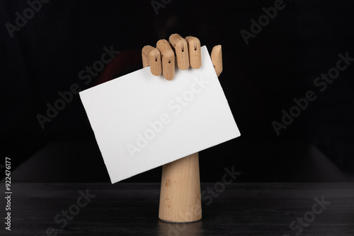 Obraz na plátne Empty blank sign being held by wooden jointed manikin hand.