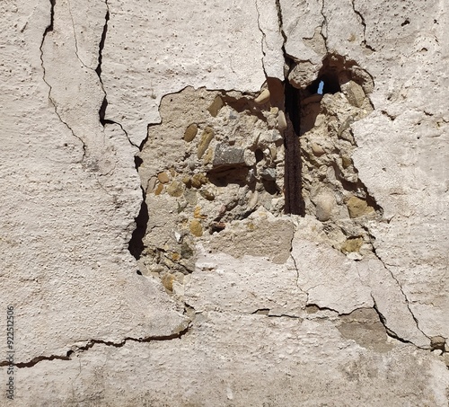 crack on the wall. old cracked concrete wall, close-up. background. destruction of layer and plaster on concrete shabby wall. a hole through the wall, rusty metal bars are visible