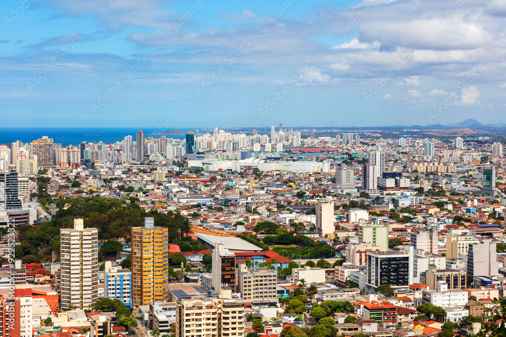 Fototapeta premium Aerial view of Vila Velha from Convento da Penha on a sunny day, highlighting Praia da Costa and Itapuã neighborhoods with the blue ocean in the background. Perfect blend of urban and coastal beauty.