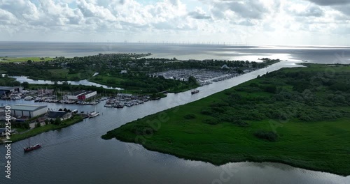 Canal Makkumer Djip leading into Makkum, Friesland, typical dutch village between the Afsluitdijk and Workum on the coast of the IJsselmeer photo