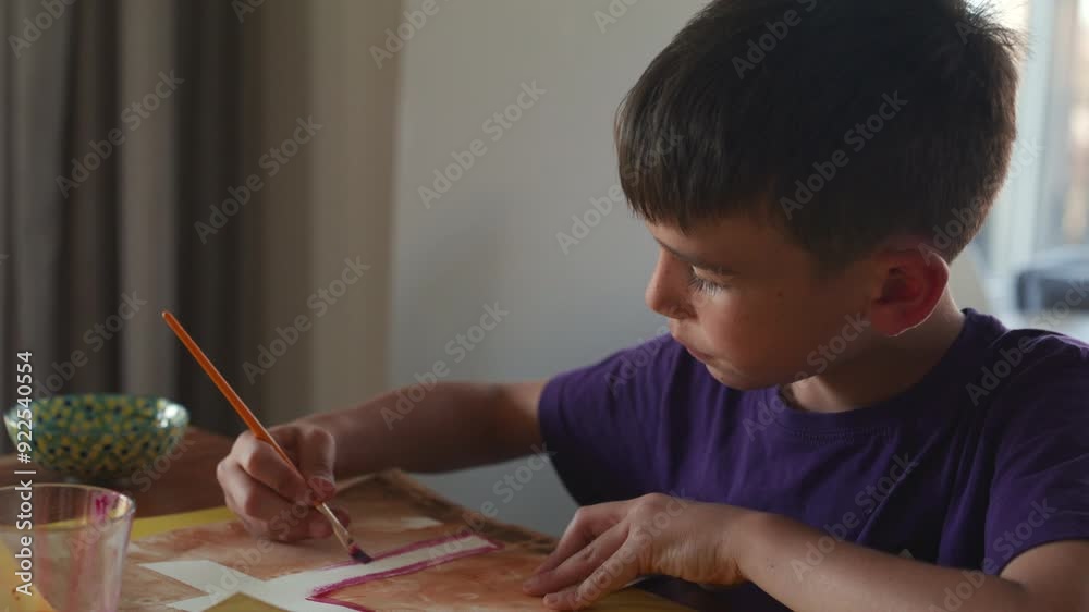 Boy painting cross artwork for first communion - pull out dynamic shot Boy painting cross artwork for first communion - pull out dynamic shot