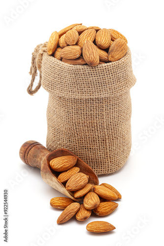 Close-up of organic Almonds (Prunus dulcis) kernels, in a jute bag and on a scoop, Isolated on a white background. photo