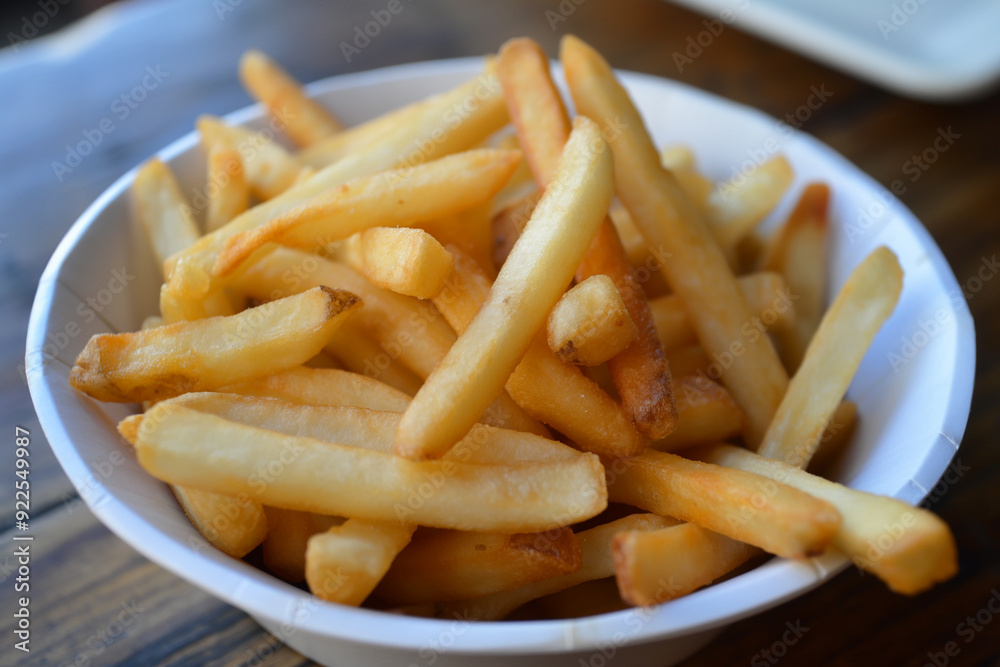 Delicious crispy golden fried potato fries in a bowl - tasty snack for lunch and dinner
